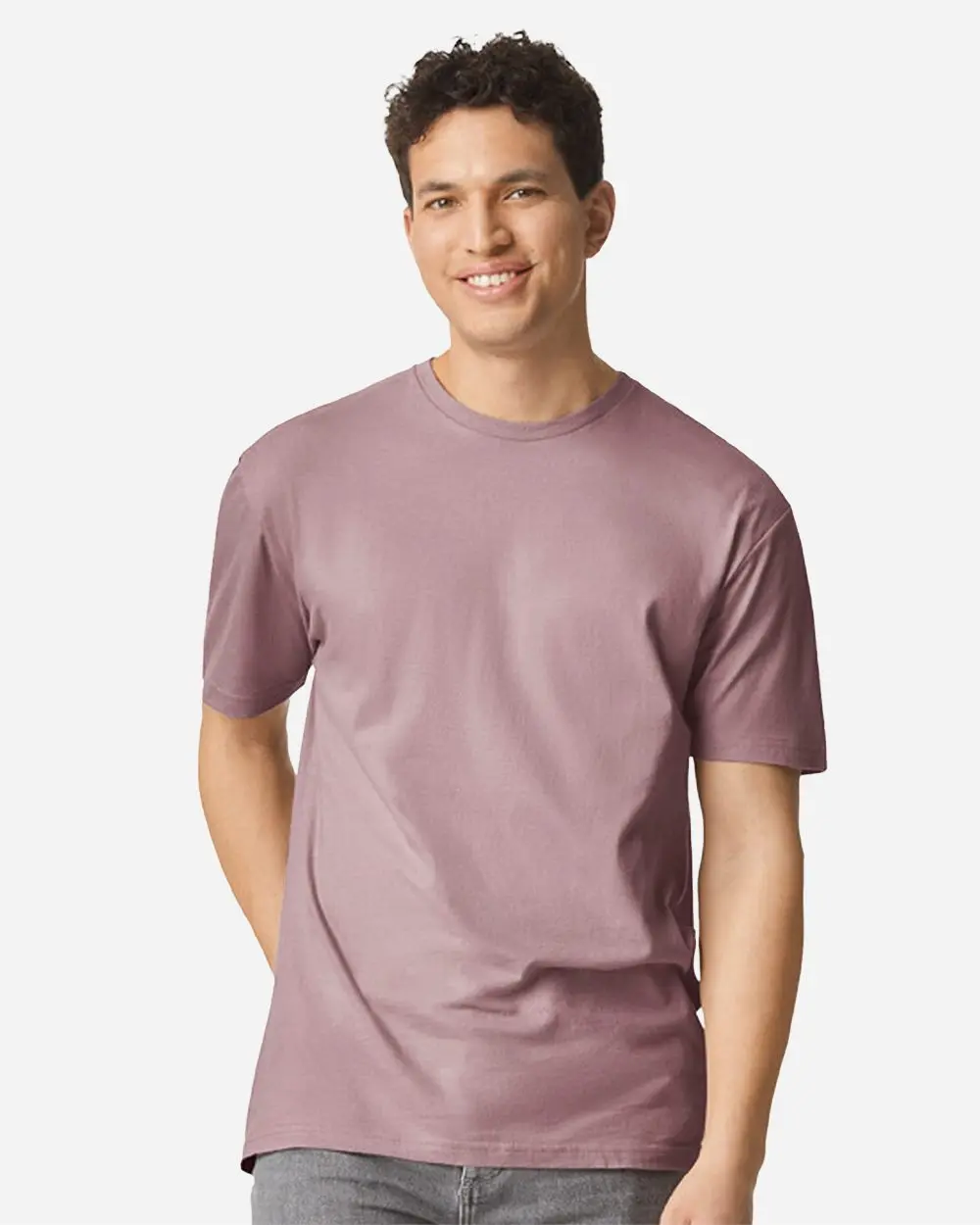 64000 | Supershirt Smiling man wearing a dusty pink short-sleeve t-shirt, standing against a light background.
